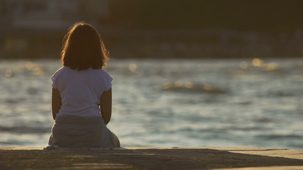 Small girl by a river bank