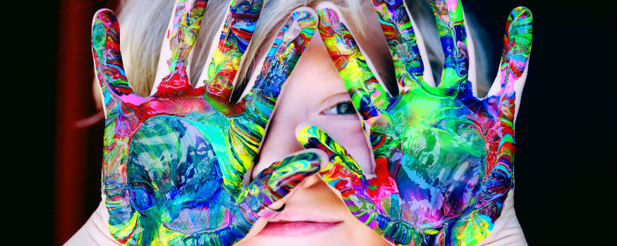 Child with hands full of colours